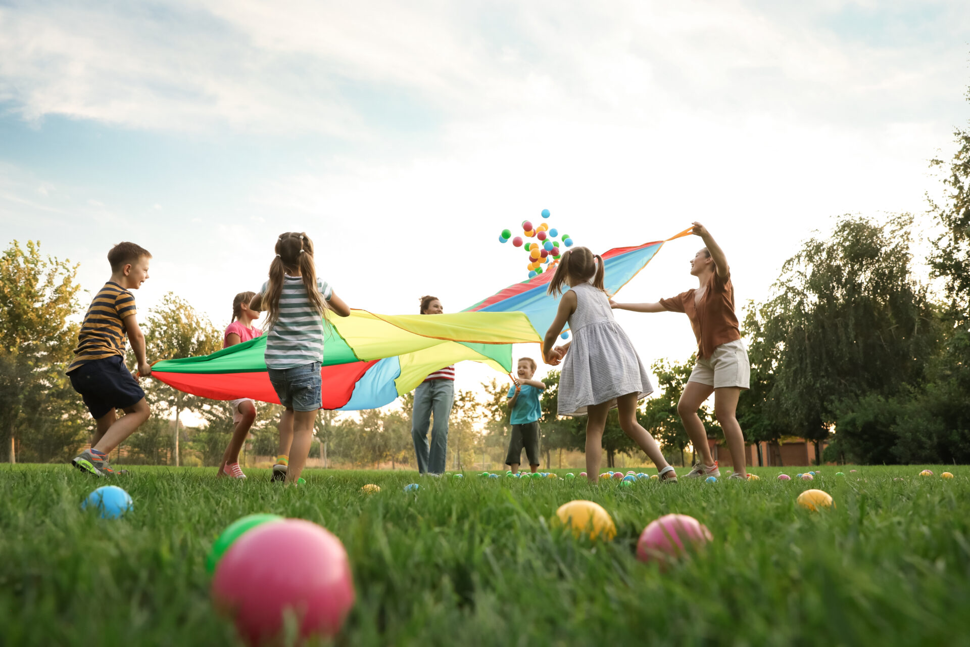 a group of children playing with a giant parachute